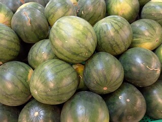 Stack of Watermelons. Watermelons on supermarket shelf. Fresh organic water melon fruit for sale in grocery store. Ripe and fresh watermelons piled up in a store. A lot of watermelons.