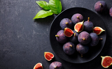 Fresh figs on black plate. Dark background. Top view. Copy space.