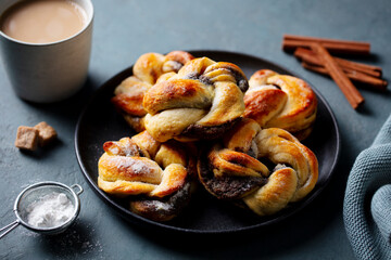 Cinnamon and cardamon buns, rolls, Kanelbullar, swedish traditional pastry. Dark background. Close up.
