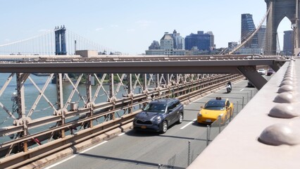 Cars on Brooklyn Bridge, New York City Manhattan Bridge view. Yellow taxi cab, road traffic and architecture. Iconic landmark on East River. Travel USA.