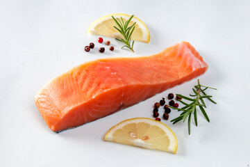 Juicy slice of fresh salmon with ingredients closeup isolated on a white background
