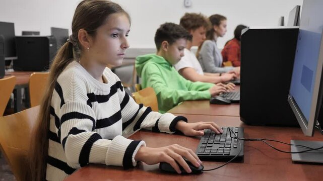 Schoolgirl using computer during computer sciene lesson in school.