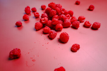 Side view to the fresh raspberry at the red background