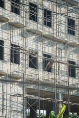 Extensive scaffolding providing platforms for work in progress on a new apartment block,Tall building under construction with scaffolds,Construction Site of New Building