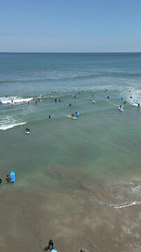 Aerial view of people taking surfing lessons in the ocean, Bali, Indonesia
