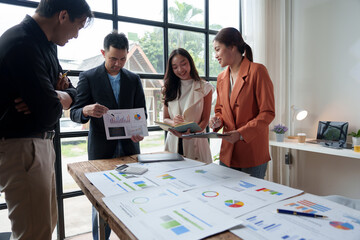 A team of male and female businessmen work together to inspect sales documents. Marketing analysis...