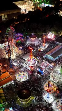 Night view vertical video of amusement park - high quality aerial footage of people having fun at the amusement park and amusement park rides taken with drone
