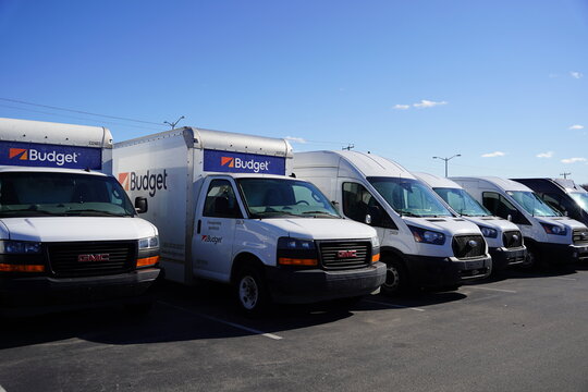 Budget delivery hauling Trucks and Vans sit parked in the parking lot. 