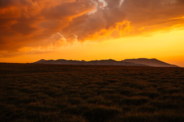 Sunset on Romania Transalpina road with many serpentines crossing forest in  Carpathian mountains. Mountains forest trees with road in Parang mountains