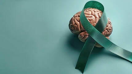 green awareness ribbon and human brain on solid light green background . World mental health day banner