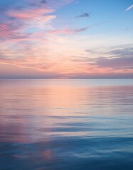 Obraz premium A calm ocean with soft, pastel colors at sunrise, reflecting gentle hues of peach