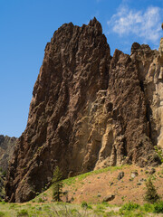 A mountain with a rocky peak and a green hillside