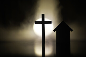 Silhouette of Cross and House with Bright Light Background - Symbolizing Faith and Home