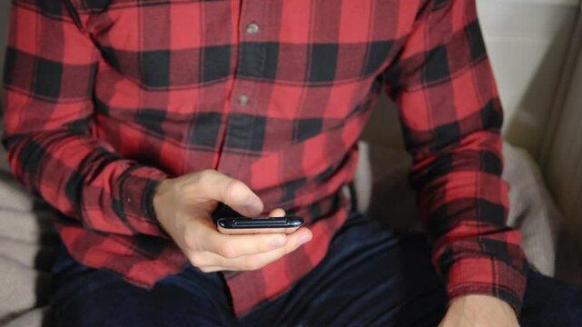 Konzentrierter junger Mann beim Scrollen am Smartphone