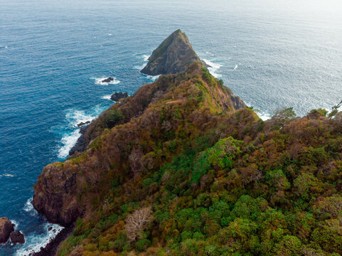 Aerial drone view of cliff hill by the blue sea scenery at Orong Bukal in Buwun Mas, Lombok, Indonesia.