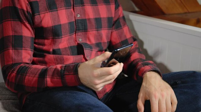 Social Media Nutzung: Mann checkt Updates und scrollt durch Inhalte auf seinem Handy.
