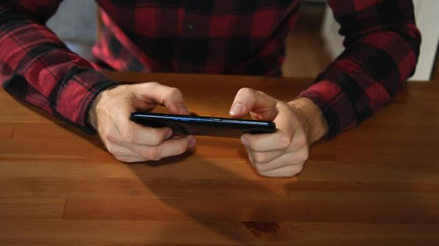 Mann in Freizeitkleidung schreibt auf seinem Handy
