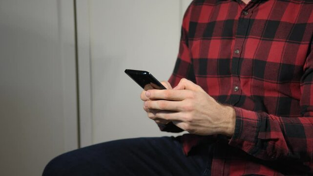 Junger Mann konzentriert beim Schreiben am Smartphone