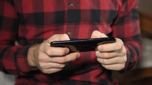 Junger Mann tippt Nachrichten auf dem Smartphone