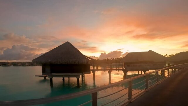 夕暮れにボラボラ島の水上コテージまでの桟橋を歩く