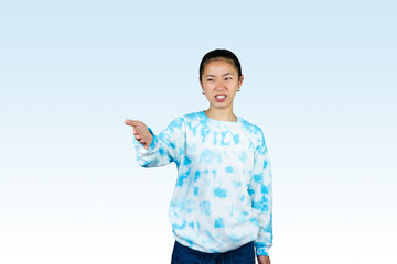 Yougn Asian girl with blue dress points and gives various expression and gestures isolated happy sad