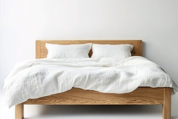 A simple oak bed frame with two white linen pillows and a duvet on it