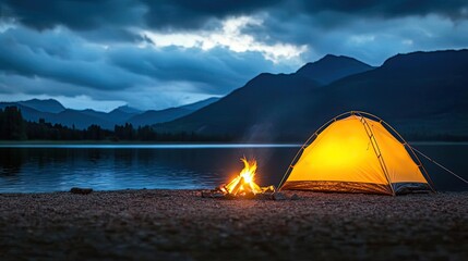 Tent by the lake with a warm fire under a dramatic cloudy sky.