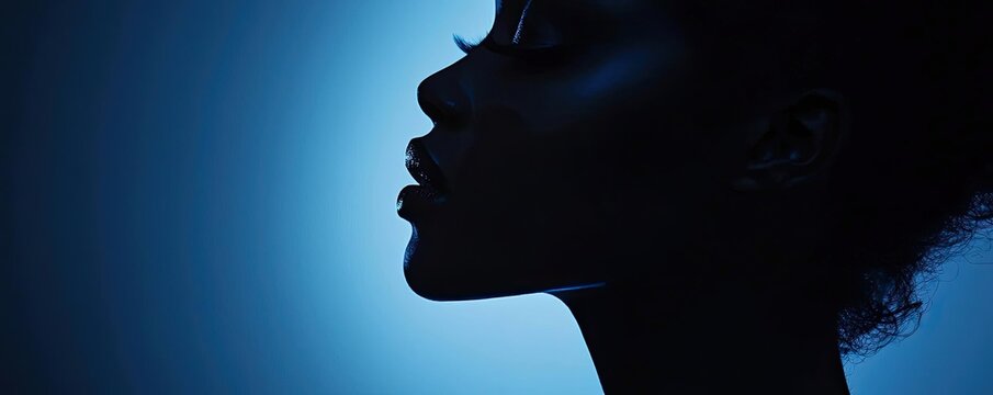 Silhouette of a woman against a blue background showcasing elegance and beauty.