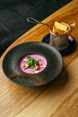 beetroot soup in a black bowl