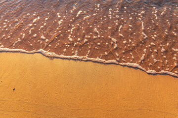 Soft wave of the sea on the sandy beach.