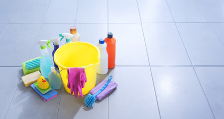 Assorted cleaning supplies and detergents on the bathroom floor © stokkete