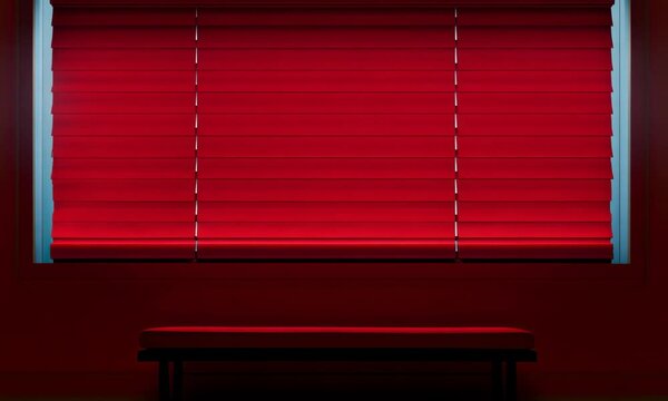 Vibrant red interior with a minimalist bench and decorative blinds