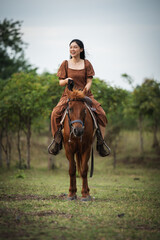 happy woman riding horse on meadow field