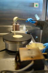 an asian chef is tossing cheese on the pan into a wok