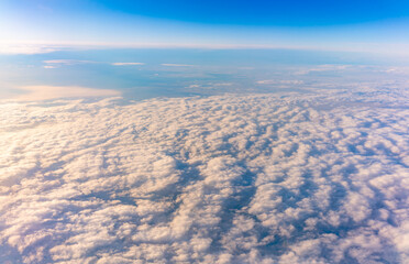 Beautiful orange and pink sunrise over the clouds, view from the plane.