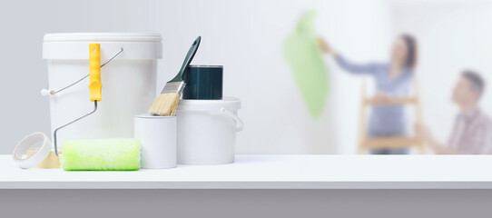 Couple painting walls and professional painting equipment © stokkete