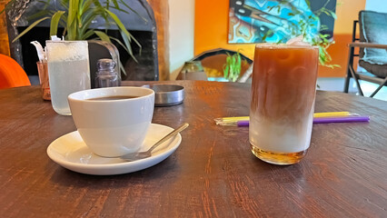 Coffee and cold latte served on a wooden table.