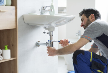 Professional plumber fixing a bathroom sink