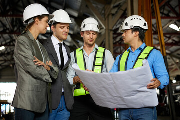 engineers and businesspeople talking about work or project on a construction site