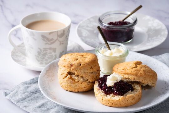  homemade scone 1 -  white marble backbround 1 - jam and cream on the scone 1