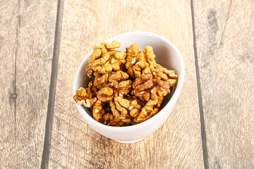 Cracked unshelled walnut in the bowl