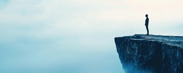 A figure standing on a cliff, gazing into the misty distance.