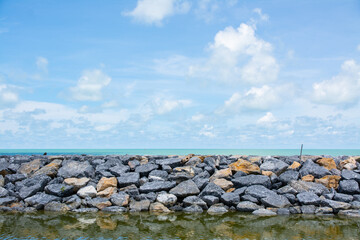 Stone dam protecting the long beach along Pak Phanang in Thailand