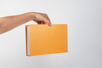 Blank book cover in hand on white background.