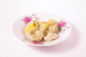 a siomay with fish balls, potatoes and tofu on a white background isolated