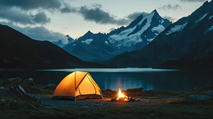 Camping tent illuminated by a fire under a starry mountain night sky.