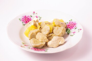 a siomay with fish balls, potatoes and tofu on a white background isolated