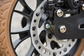 Disc brake on the rear wheel of a scooter. Close-up.