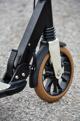 Front wheel of a scooter on asphalt. Close-up.