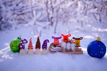 Dwarf figurines and gifts with smiles made of plasticine on a background of snow. Festive decorations for children.